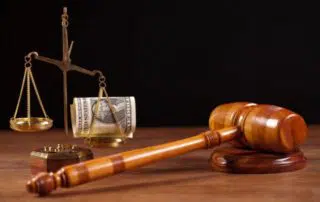 gavel and scales of justice with dollar bill on one side